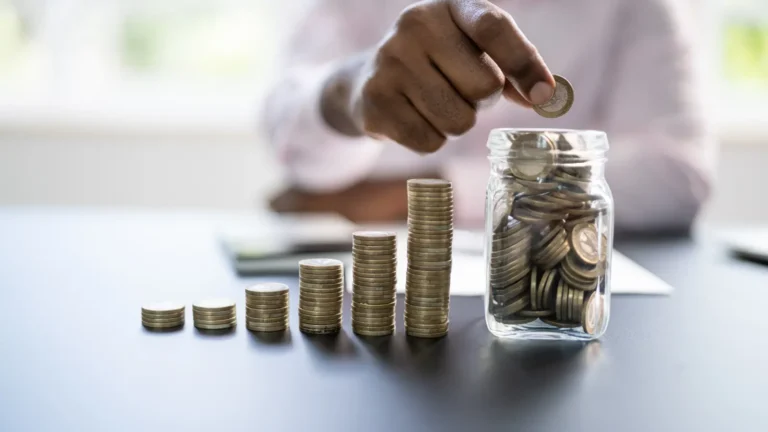 man putting coins into a jar
